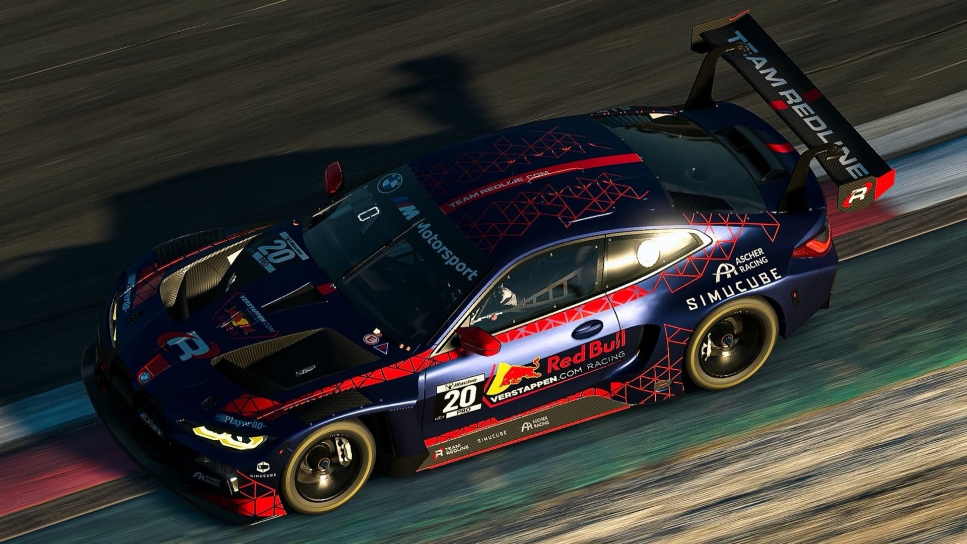 A Team Redline BMW M4 GT3 race car pushing the limits of the track, with the inside tires barely within the track limits on the dark blue and red machine..