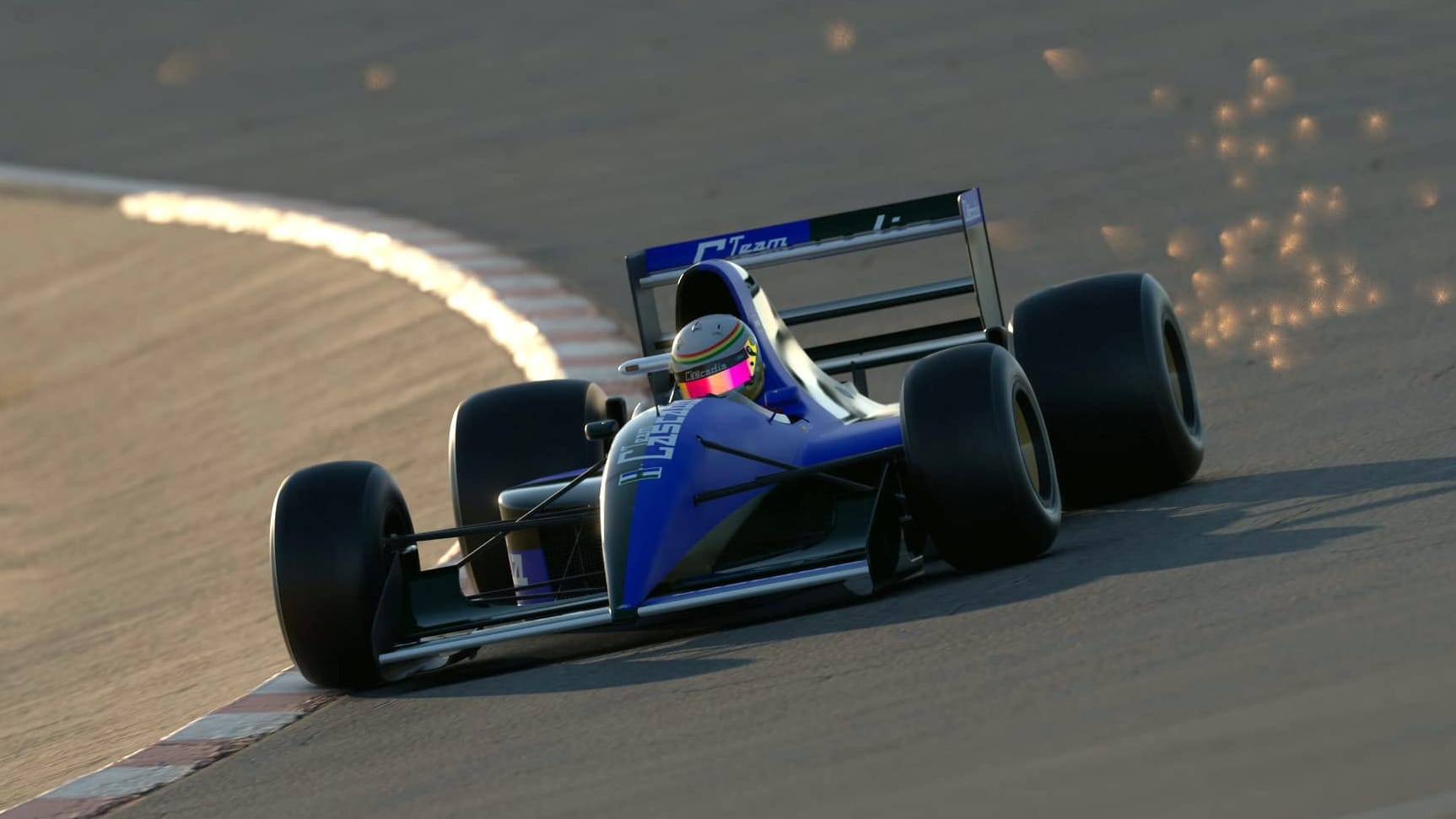 A blue and green half and half liveried open wheel race car goes through a corner at speed, with sparks flying off the floor of the car.