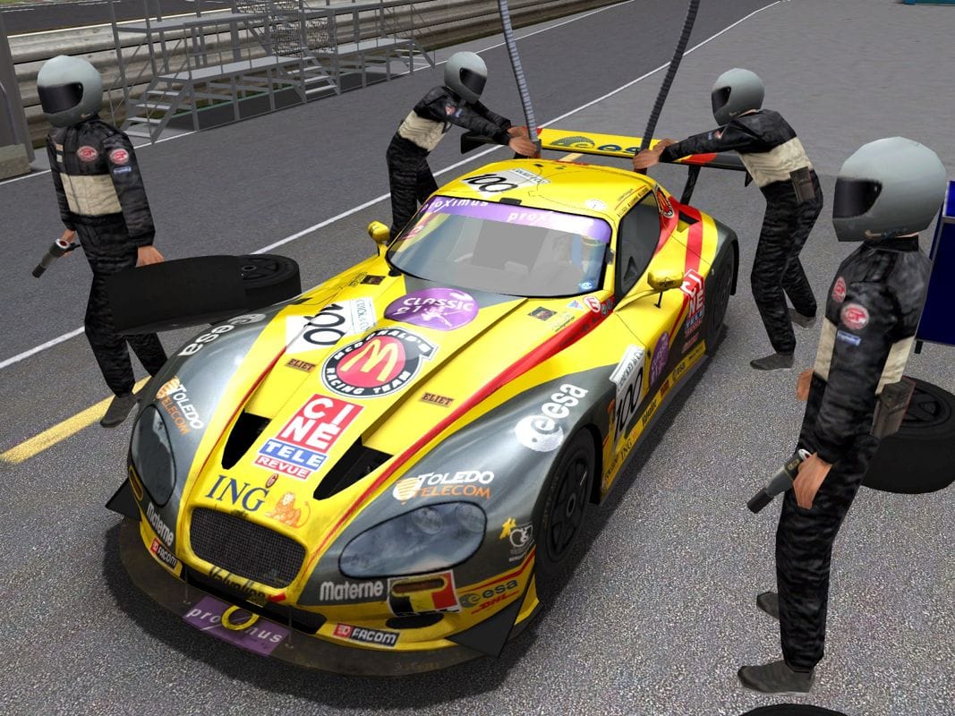 A yellow and dark grey Gillet Vertigo race car getting refuelled with two fullers standing on either side of the rear of the car with their fuel hoses attached into the back glass. It is a screenshot from GTR2..