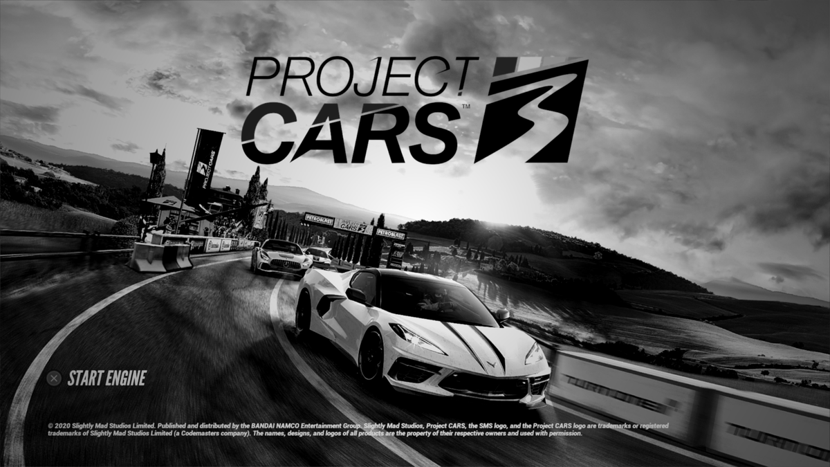 The title screen for Project CARS 3, made to be black in white. A C8 Corvette is leading a Mercedes AMG GT through the tuscan countryside.
