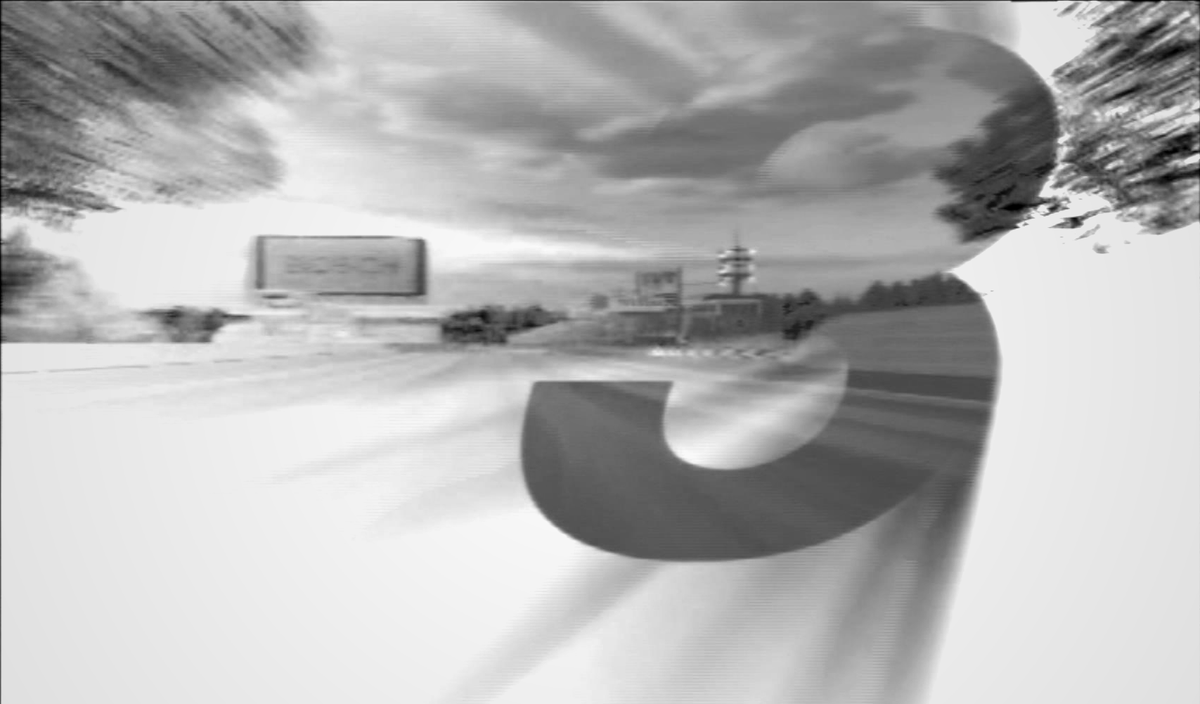 A screenshot from the intro to Gran Turismo 3, where the number 3 gets a outer glow effect superimposted in front of a moving race track.