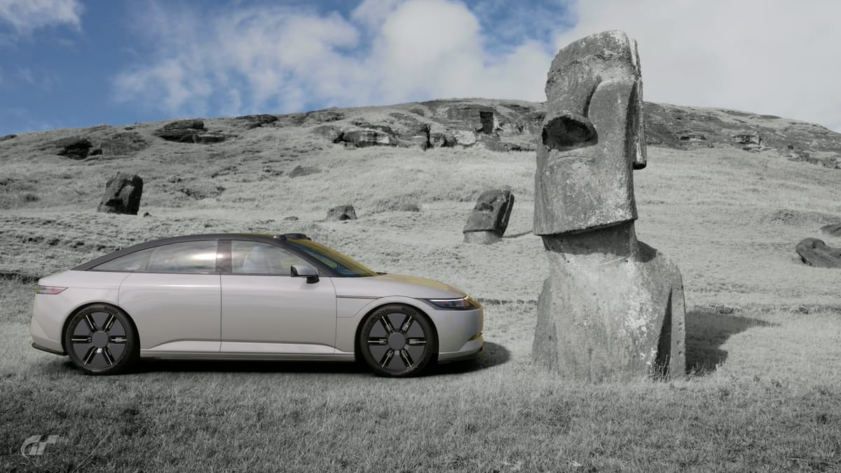 A Sony Honda Afeela 1 sedan parked beside an Maoi on Easter Island.
