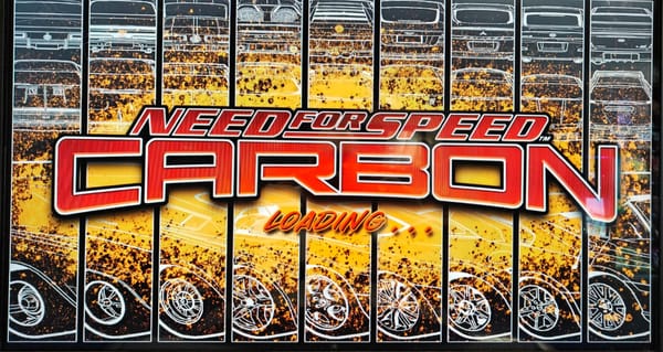 The pre-race loading screen for Need For Speed Carbon arcade. It has the game logo in red text in the foreground, and outlines showing off different cars against a yellow splash graphic. 