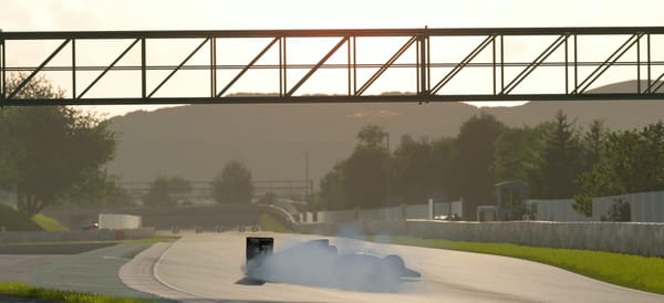 A open wheel racing car spinning off track at turn 9 of the Barcelona circuit. A plume of smoke hides the car as it heads towards the gravel trap.
